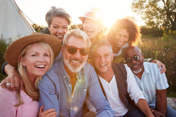 A group of older friends gathered together at sunset, smiling